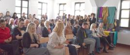 zdjęcie grupowe , na auli uczniowie wraz z nauczycielami siedzą w ławkach