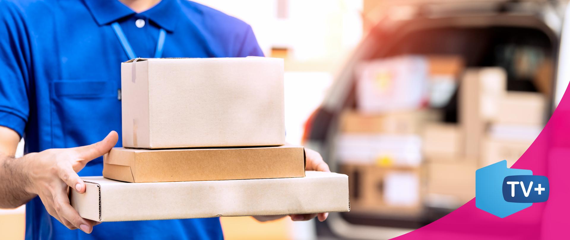 Zdjęcie przedstawiające kuriera trzymającego w rękach paczki