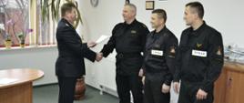 Komendant Powiatowy PSP w Grodzisku Mazowieckim st. bryg. Krzysztof Tryniszewski wręcza akt mianowania na stanowisko dowódcy JRG kpt. Mariuszowi Wołowskiemu. Obok stoją asp. Leszek Pintara oraz mł. asp. Jakub Dobroszek.