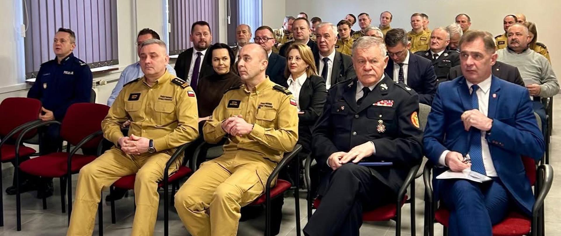 Na zdjeciu Komendanci zaproszeni goście oraz funkcjonariusz psp podczas na narady w sali koferencyjnej