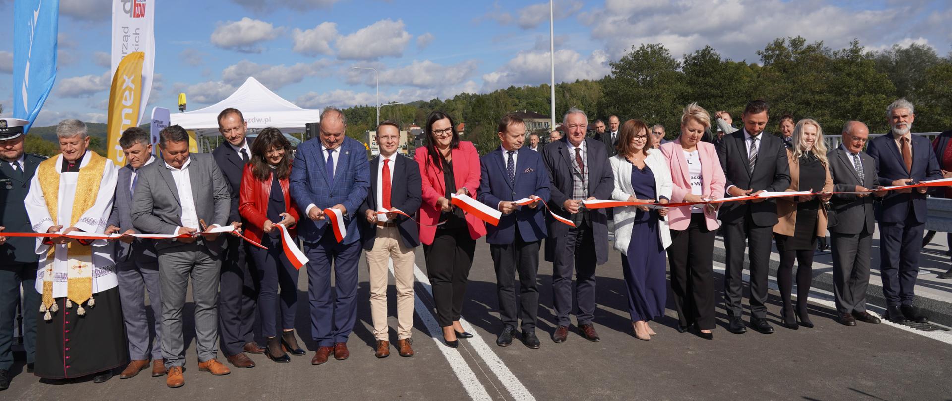 Grupa osób na szosie przecina wstęgę