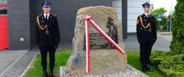 Obelisk a obok niego strażacy