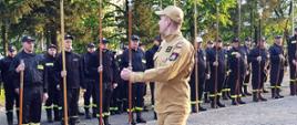 Widok z przodu. Na pierwszym planie instruktor z PSP. Na drugim planie uczestnicy szkolenia z drzewcami sztandarowymi.