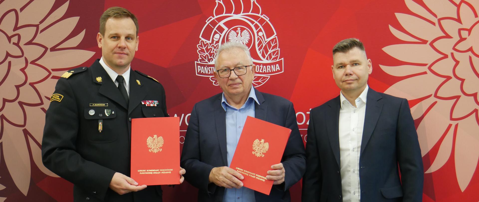 Rozbudowa i przebudowa budynku KW PSP w Gorzowie Wlkp - LKW wraz z przedstawicielami firmy budowlanej pozuje z aktem umowy w reku