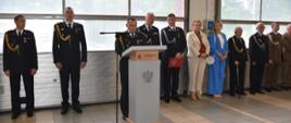 Na zdjęciu widoczny przy mównicy bryg. Grzegorz Brzozowski - Zastępca Opolskiego Komendanta Wojewódzkiego PSP. Na drugim planie widoczni: kierownictwo KP PSP w Oleśnie i zaproszeni goście.