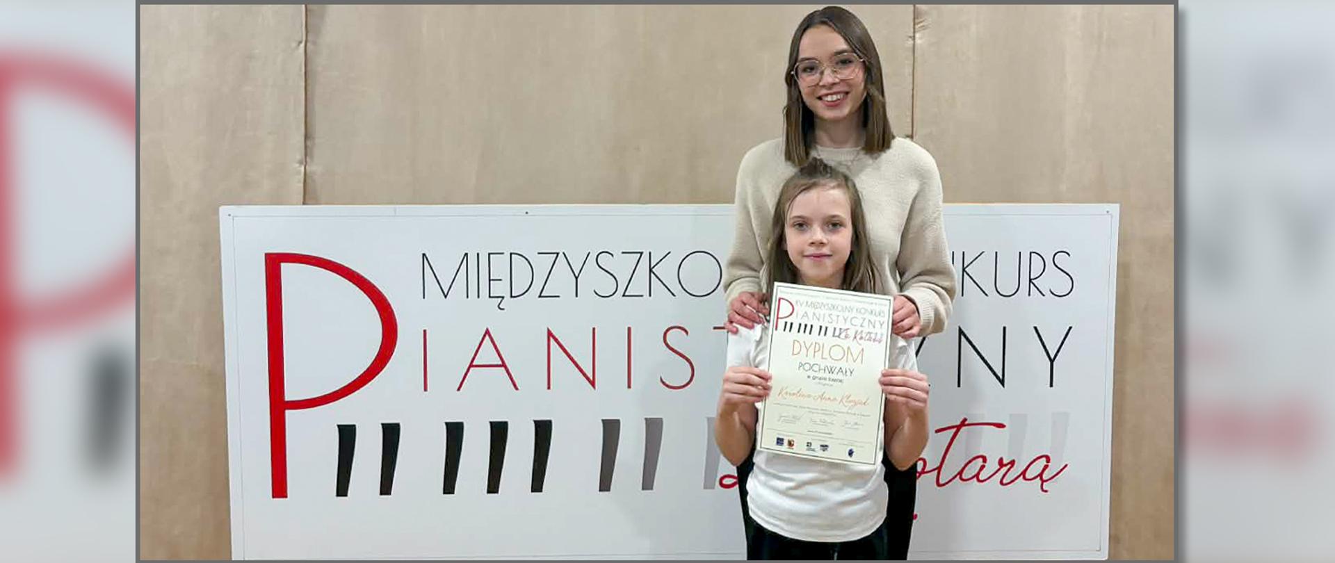 Na zdjęciu nauczycielka i uczennica, ta ostatnia trzyma w ręku dyplom.