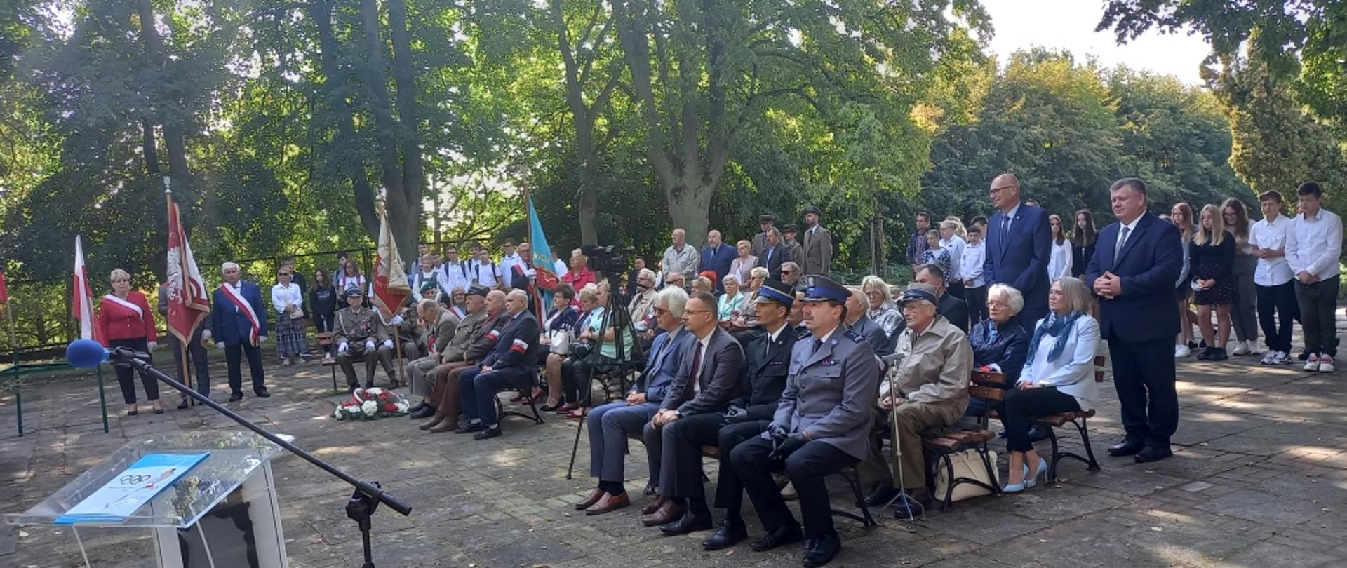 Na zdjęciu goście obchodów siedzący na krzesełkach, słuchający przemówienia.