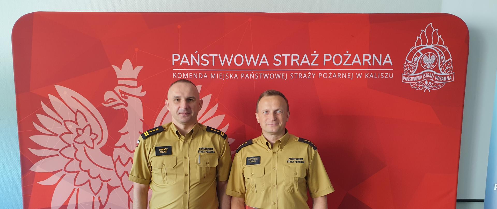 Funkcjonariusze, mundur piaskowy, czerwona ścianka, logo psp, godło