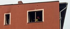 POŻAR MIESZKANIA O PORANKU. Strażacy gasili pożar mieszkania na pierwszym piętrze, widać strażaka w mieszkaniu