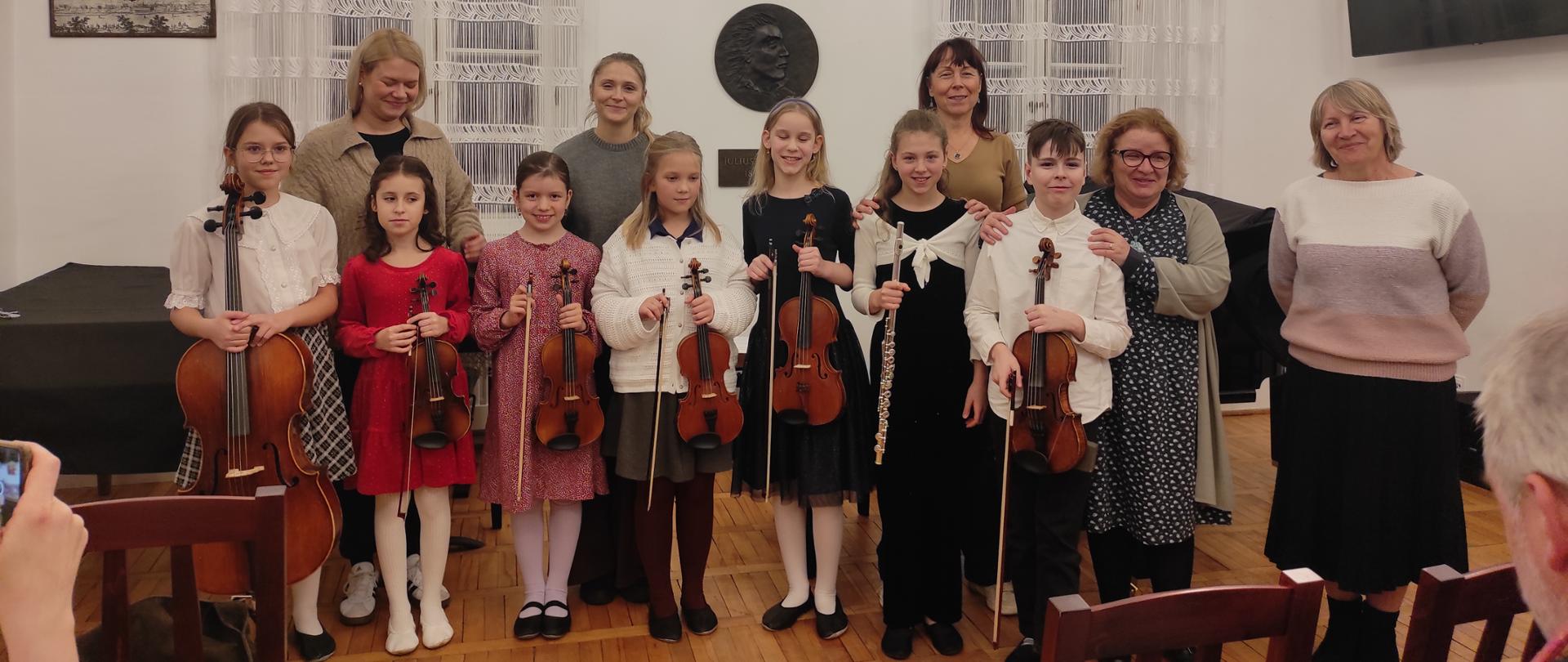 grupa dzieci z instrumentami i ich nauczyciele