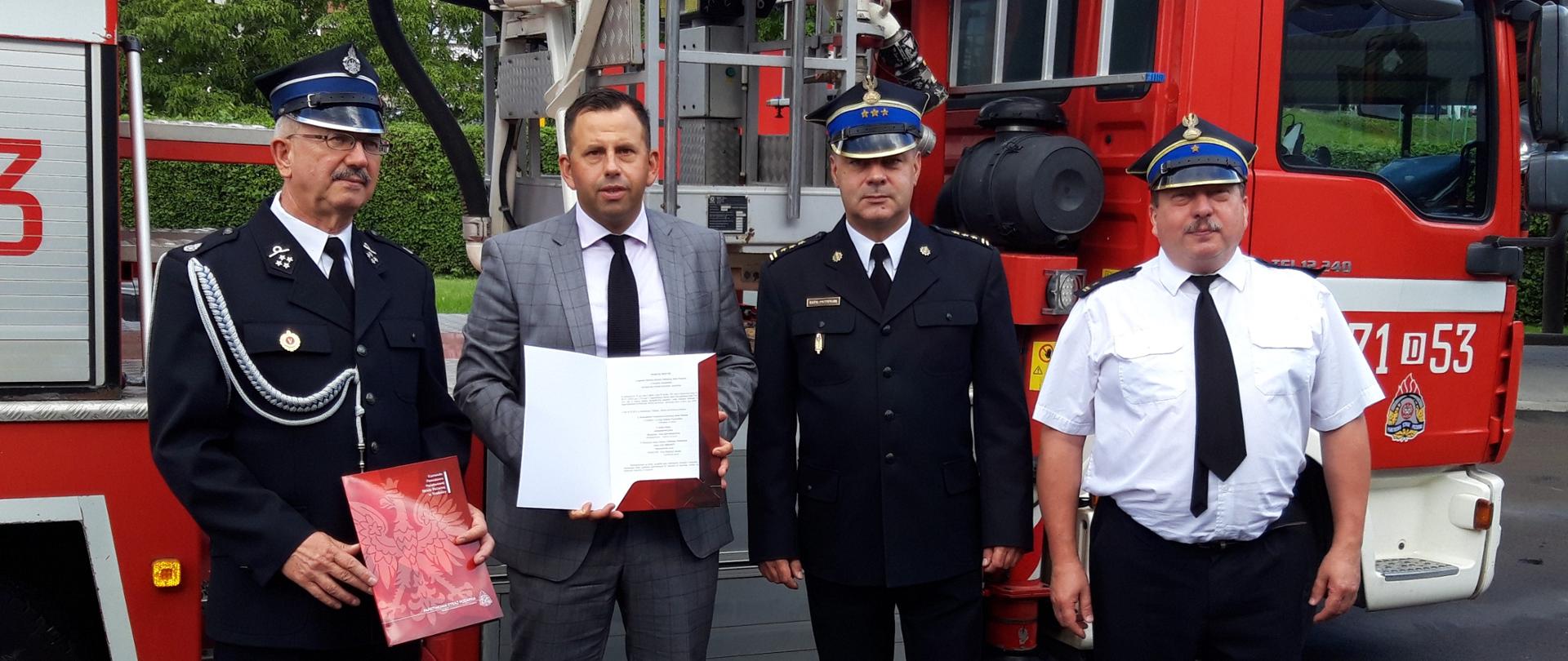 Komendant Powiatowy PSP, Burmistrz Prusic, Prezes OSP Pawłów Trzebnicki trzymający wspólnie akt porozumienia