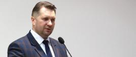 40. rocznica utworzenia Szkoły Głównej Służby Pożarniczej z udziałem ministra Przemysława Czarnka, minister Przemysław Czarnek stoi przy mównicy i przemawia, na mównicy jest napis Szkoła Główna Służby Pożarniczej.