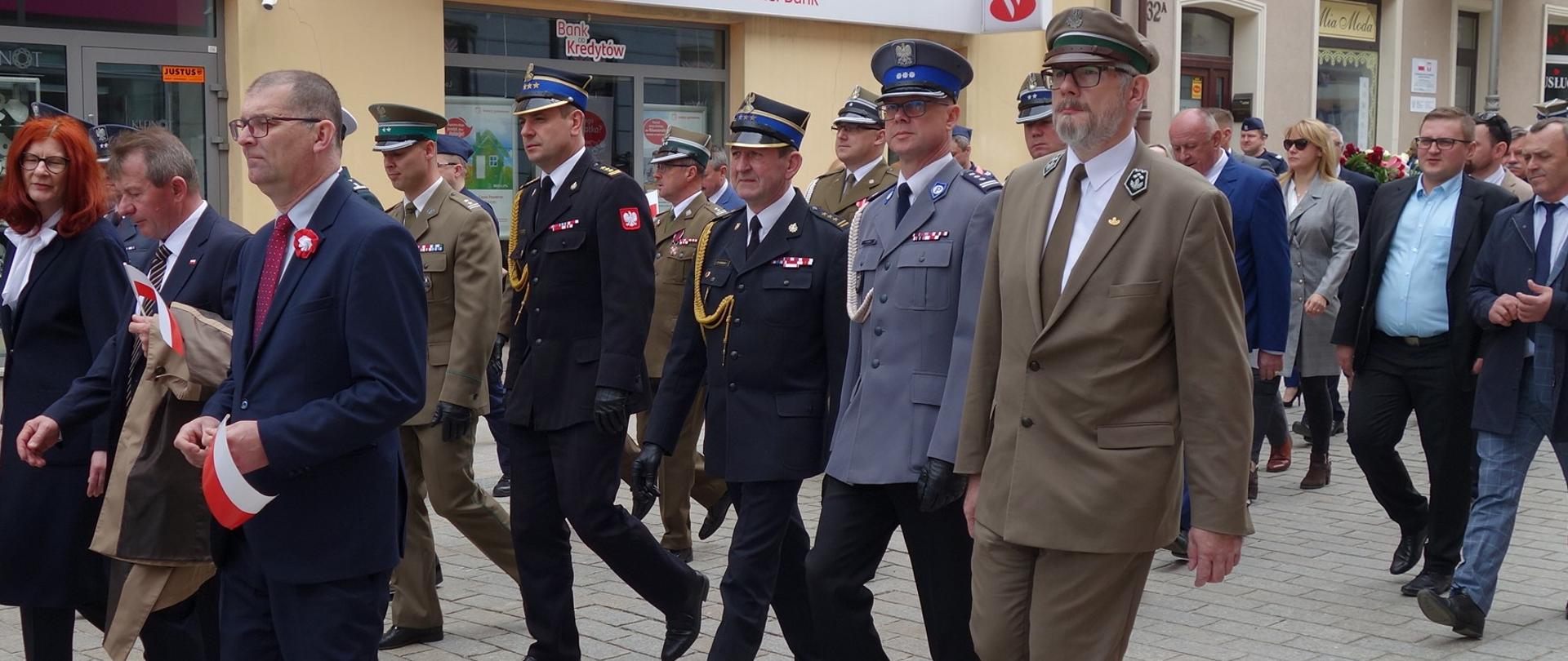Na zdjęciu przedstawiono przemarsz uczestników uroczystości 3 Maja ulicami Kielc z Bazyliki Katedralnej pod pomnik Stanisława Staszica w Parku Miejskim.