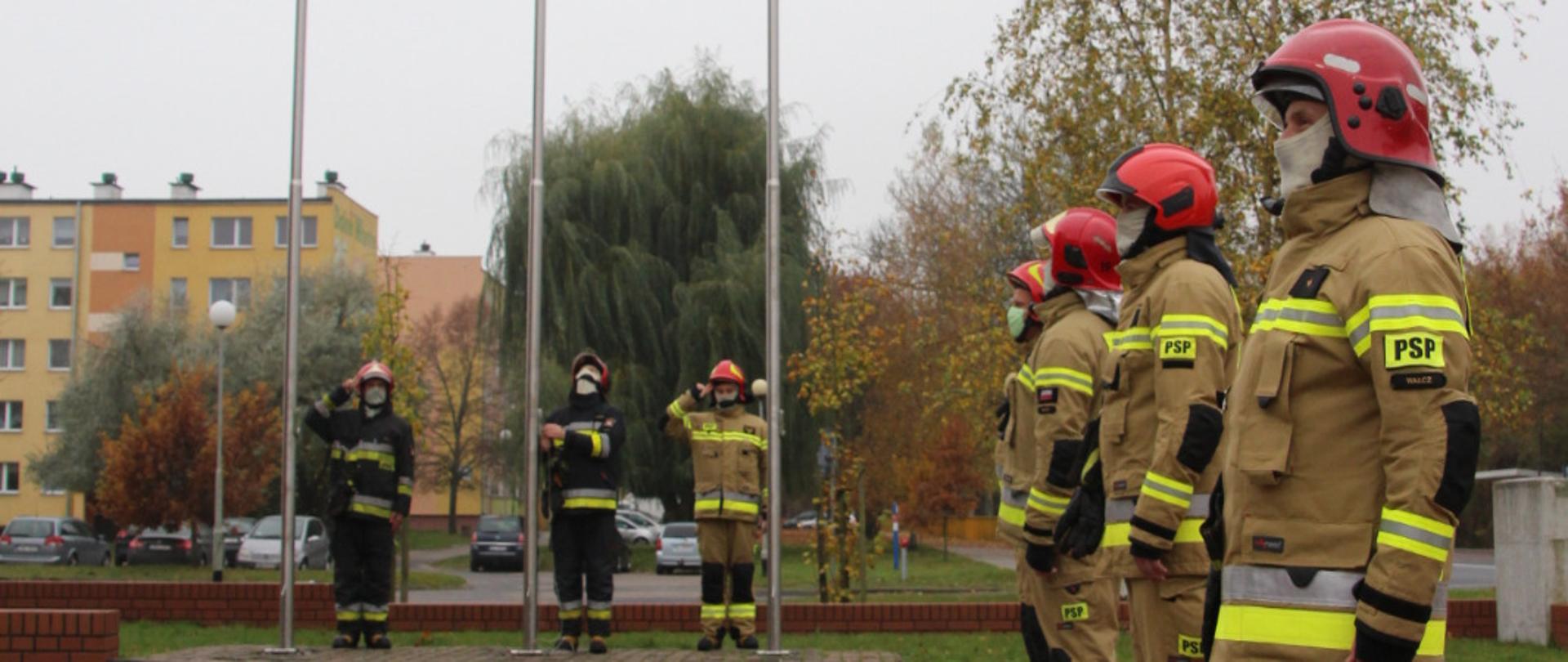 Zdjęcie przedstawia funkcjonariuszy KP PSP Wałcz, w trakcie uroczystej zmiany służby i wciągnięcia flagi państwowej.