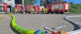 Zdjęcie przedstawia strażaków PSP oraz OSP podczas ćwiczeń, na drugim planie wozy straży pożarnych.