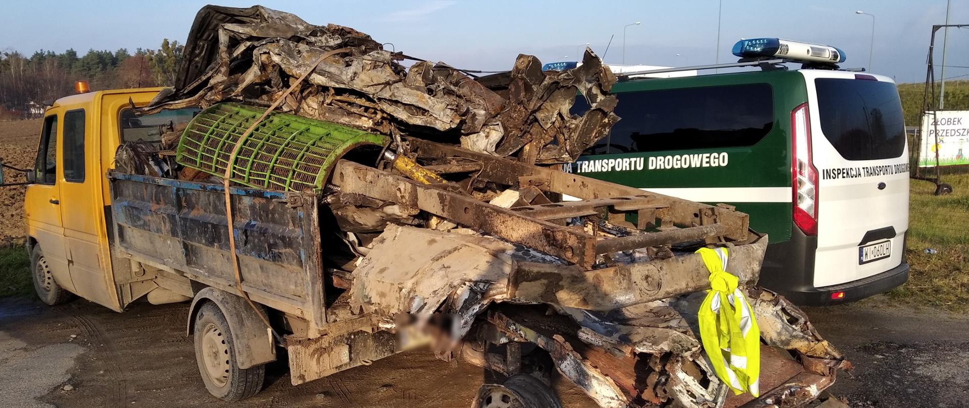 Złom wystający z tyłu dostawczaka. Obok radiowóz ITD.