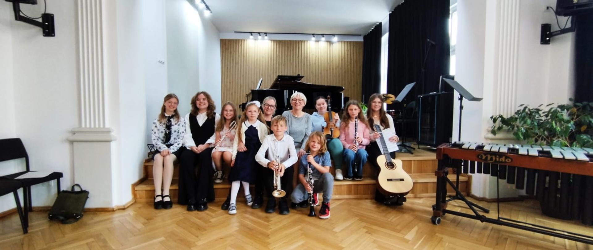 Galeria 11 zdjęć z audycji muzycznych, które odbyły się 21.05.2025 w Państwowej Szkole Muzycznej I st. w Kłodzku uczniowie grają na instrumentach na scenie sali koncertowej