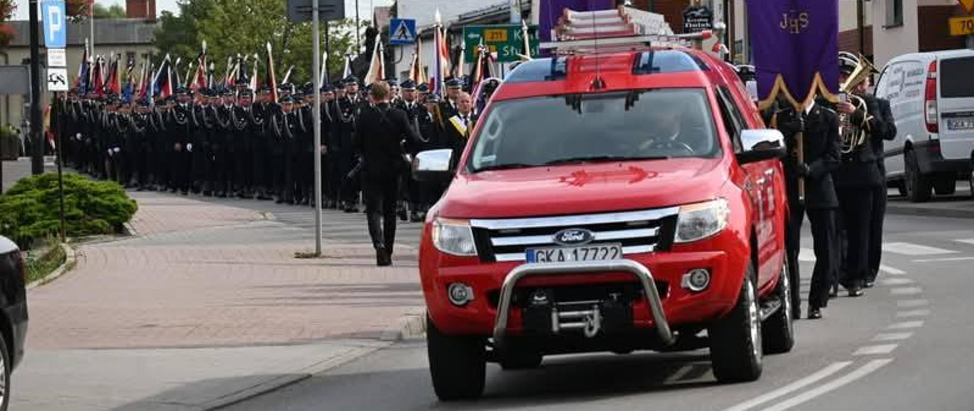 kondukt pogrzebowy idzie ulicą miasta