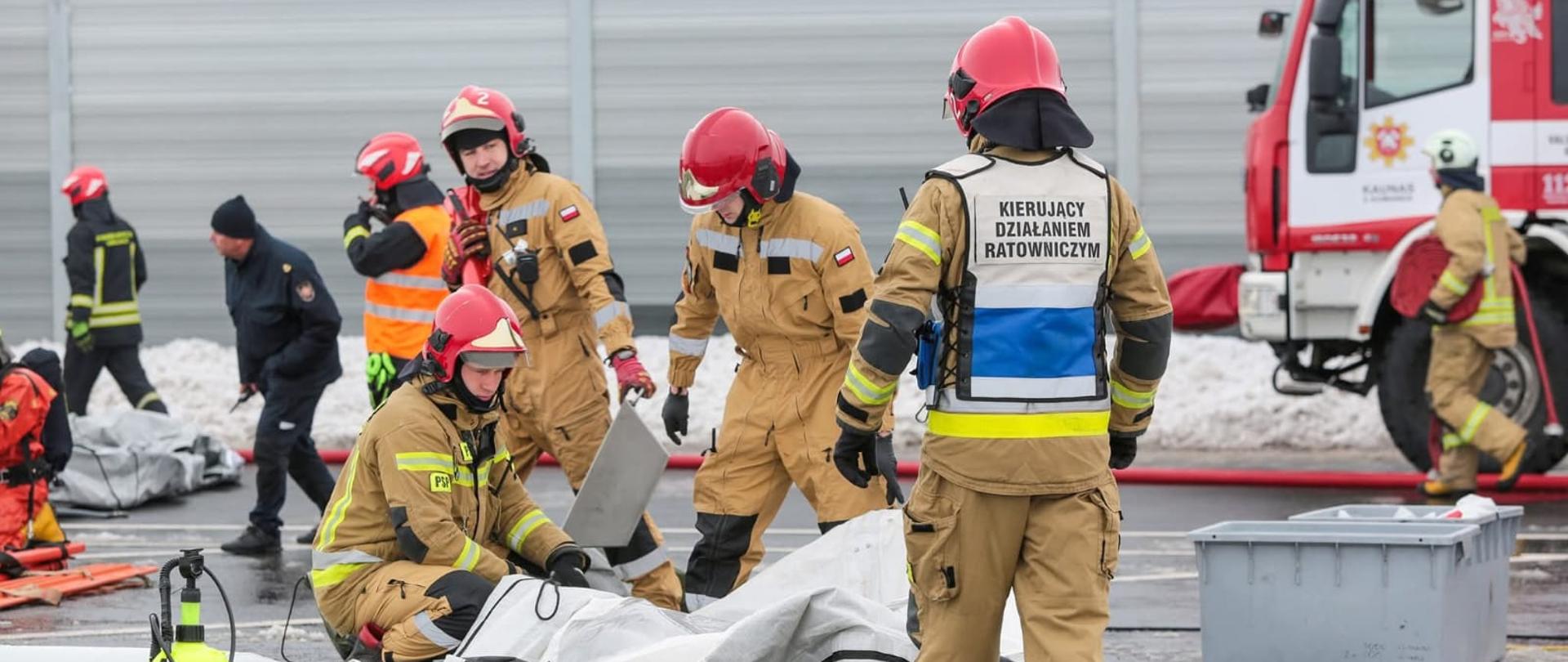 Ćwiczenia w ramach projektu LTPL00078 "Wzmocnienie współpracy litewskich i polskich służb ratowniczych w zakresie likwidacji awarii chemicznych i ekologicznych"
Na zdjęciu strażacy podczas działań, rozstawiają kabinę do dekontaminacji.