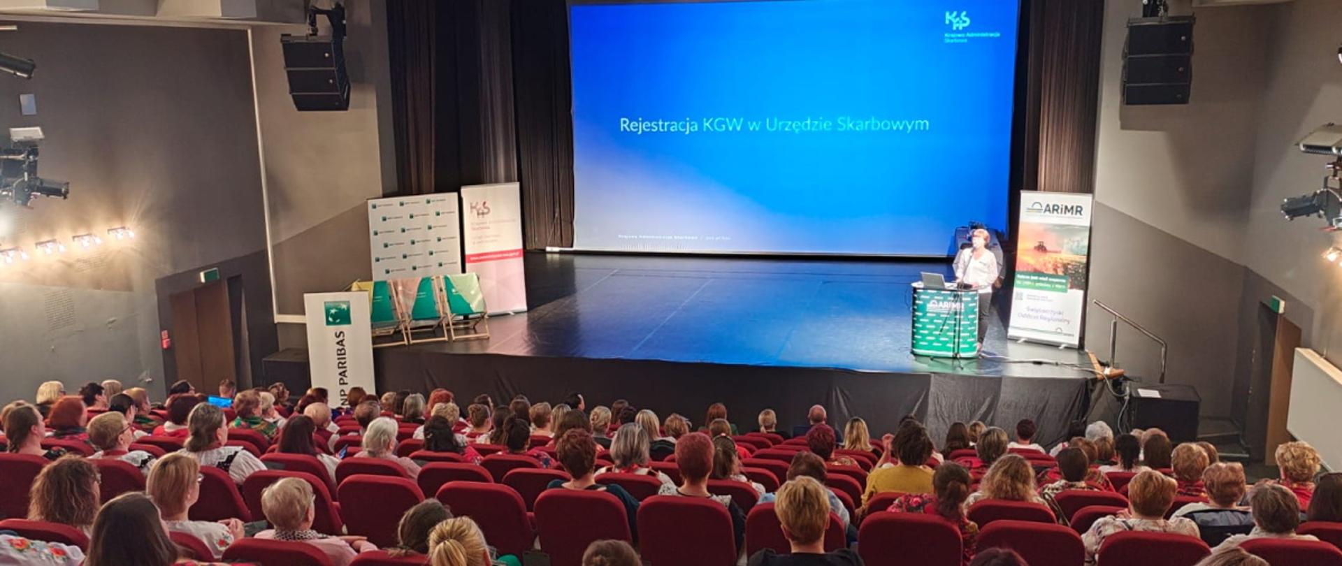 W sali siedzi duża grupa osób