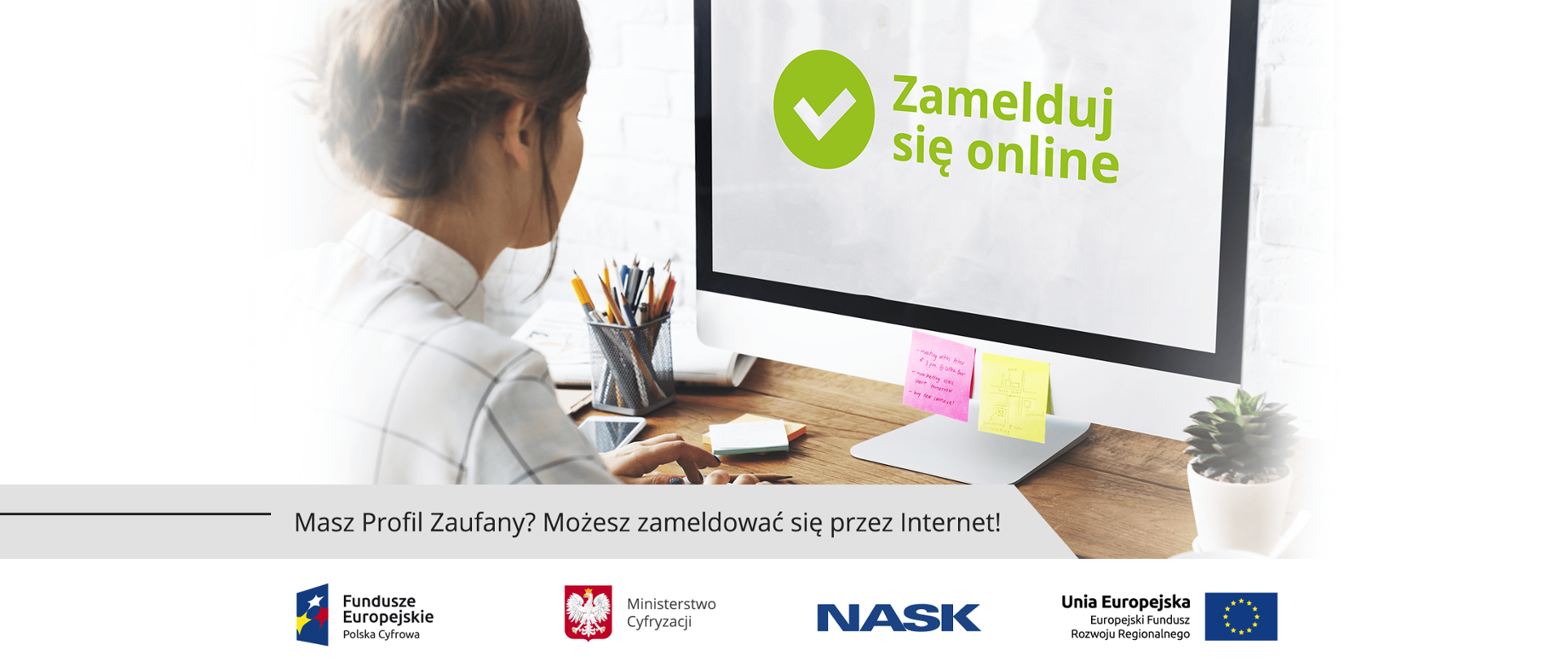 Kobieta siedząca przed monitorem z napisem "Zamelduj się online".