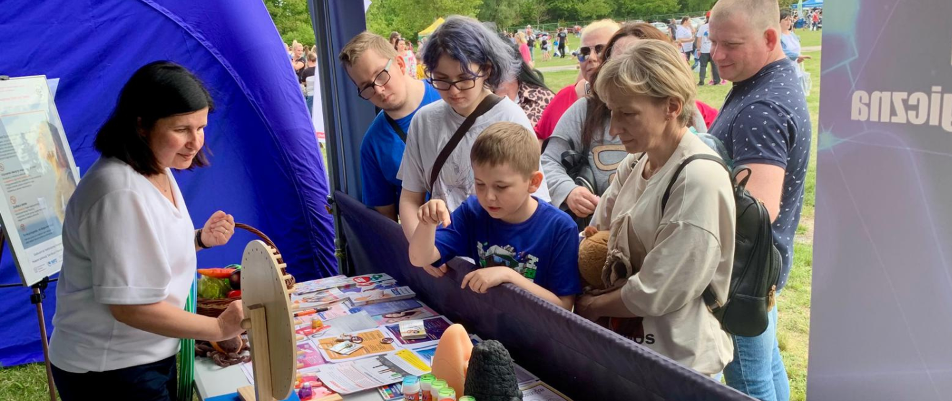 Rodziny przy stoisku edukacyjnym WSSE i PSSE w Bydgoszczy podczas festynu w Myślęcinku.