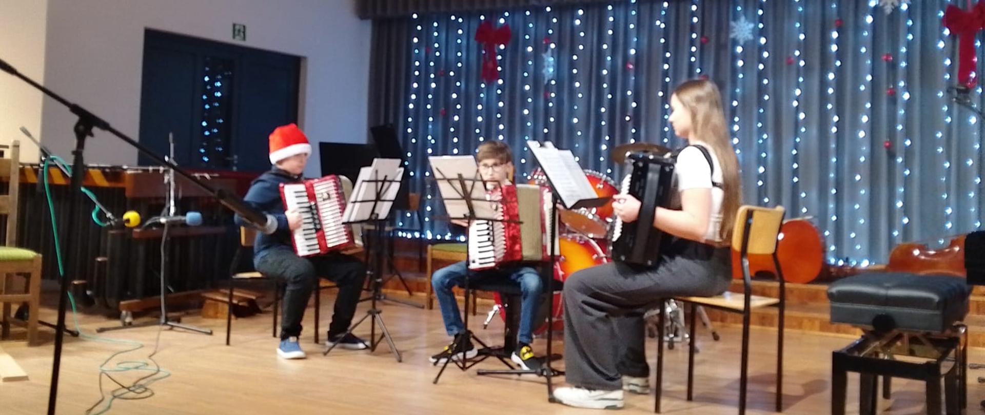 Uczniowie i nauczyciele występują na scenie szkoły muzycznej