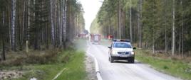 Strażacy budujący magistralę wodną z linii strażackich ułożonych na dojeździe pożarowym