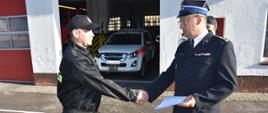 Ostródzki Komendant Powiatowy Państwowej Straży Pożarnej st. bryg. Tomasz Ostrowski wręcza mł. kpt. Damianowi Koch decyzje o awansie stanowiskowym