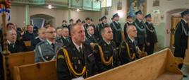 Na zdjęciu widoczni strażacy PSP i OSP w ubraniach galowych oraz zaproszeni goście w kościele na mszy świętej przed uroczystym apelem z okazji przekazanie samochodu ratowniczo-gaśniczego dla OSP Smerekowiec