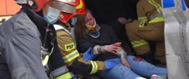 Strażak udziela pierwszej pomocy poszkodowanej