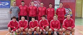 Zdjęcie pamiątkowe drużyny - reprezentacji SA PSP w Krakowie - ustawieni w dwóch rzędach mężczyźni w czerwonych sportowych strojach.