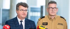 Na zdjęciu wiceminister Maciej Wąsik podczas udzielania wywiadu. Na zdjęciu po prawej stronie Zastępca Komendanta Głównego PSP nadbrygadier Krzysztof Hejduk w umundurowaniu służbowym. 