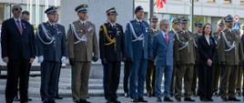 Podczas uroczystego apelu z okazji Dnia Flagi RP i Święta Narodowego Trzeciego Maja delegacje żołnierzy oraz przedstawicieli służb mundurowych oddają hołd przed Grobem Nieznanego Żołnierza. W centralnym punkcie zdjęcia widoczna jest reprezentacja Dowództwa Garnizonu Warszawa oraz kierownictwa resortów, w tym przedstawiciele PSP.