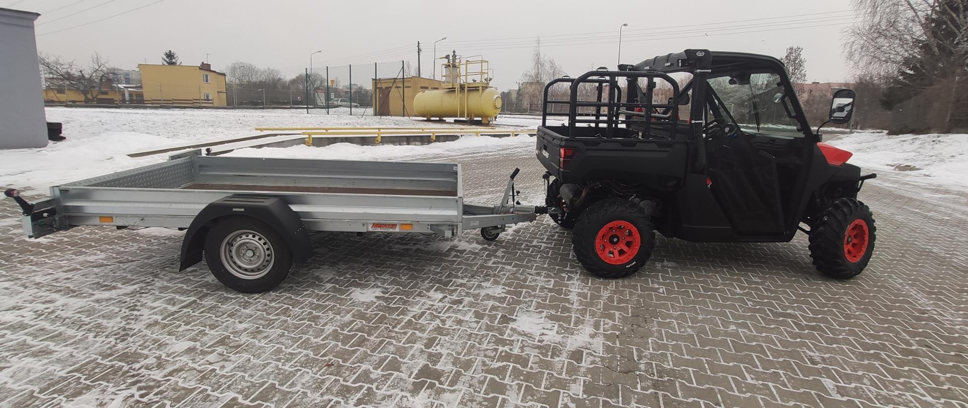 sprzęt wielozadaniowy z przyczepką stoi na pozbruku