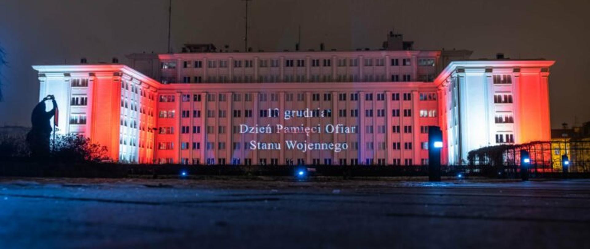 Budynek Podkarpackiego Urzędu Wojewódzkiego w Rzeszowie , na nim biało-czerwona iluminacja i napis 13 grudnia Dzień Pamięci Ofiar Stanu Wojennego