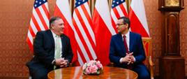Michael Pompeo i premier Mateusz Morawiecki siedzą przy stole i rozmawiają.