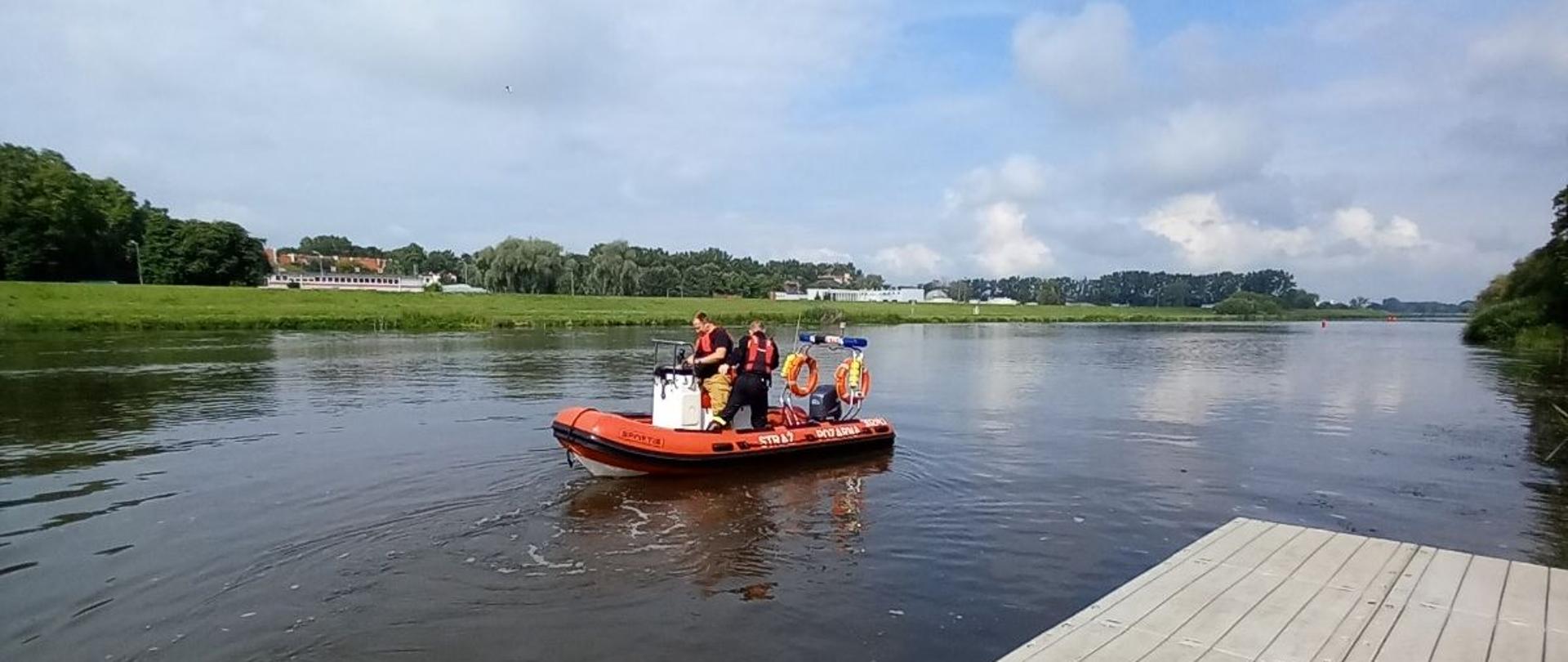 Strażacy Państwowej Straży Pożarnej oraz ochotniczych straży pożarnych ubrani w kamizelki asekuracyjne i ratownicze pływają na łodzi hybrydowej PSP. Strażacy podczas szkolenia nabywają praktycznych umiejętności sterowani łodzią motorową przy podeście na Odrze.