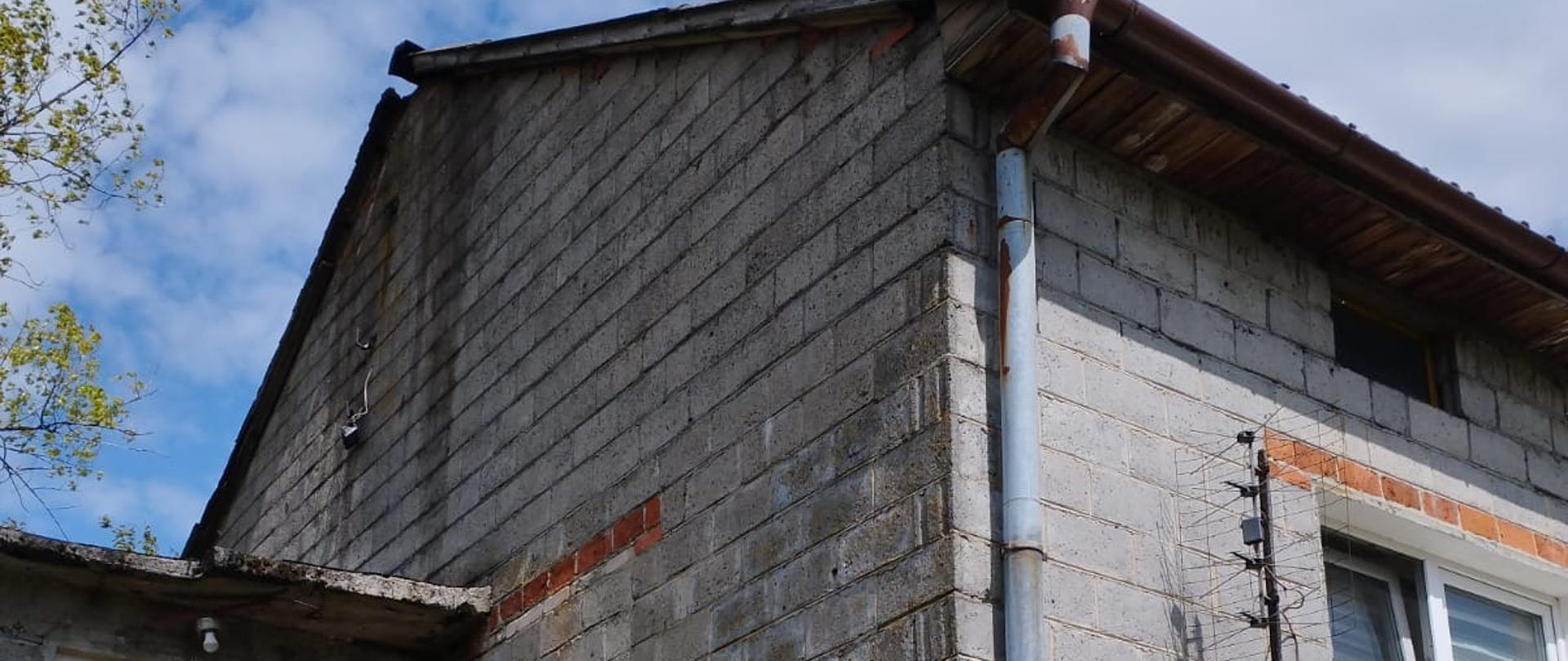 Zdjęcie przedstawia budynek mieszkalny, a właściwie jego górną część, czyli poddasze nieużytkowe gdzie doszło do pożaru konstrukcji dachowej.