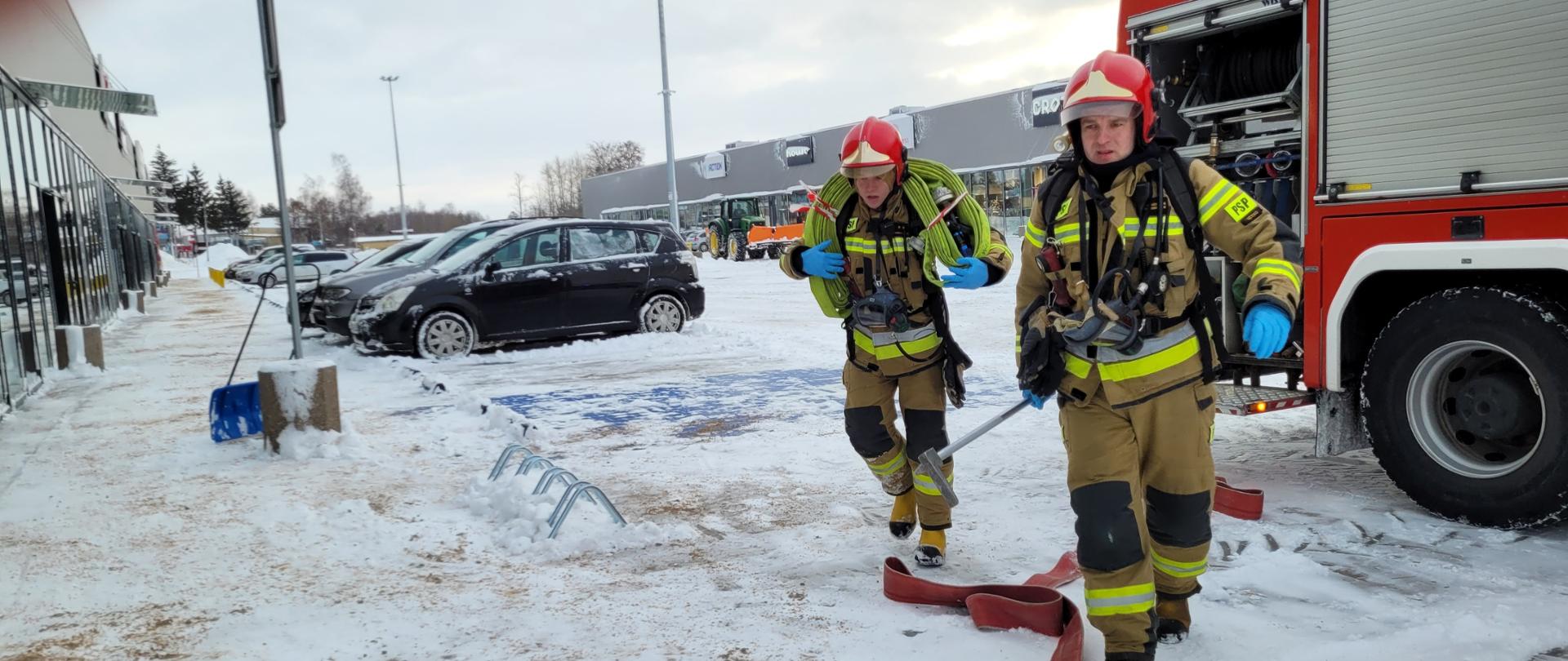 Strażacy sprawiają sprzęt ratowniczo- gaśniczy podczas ćwiczeń na obiekcie.