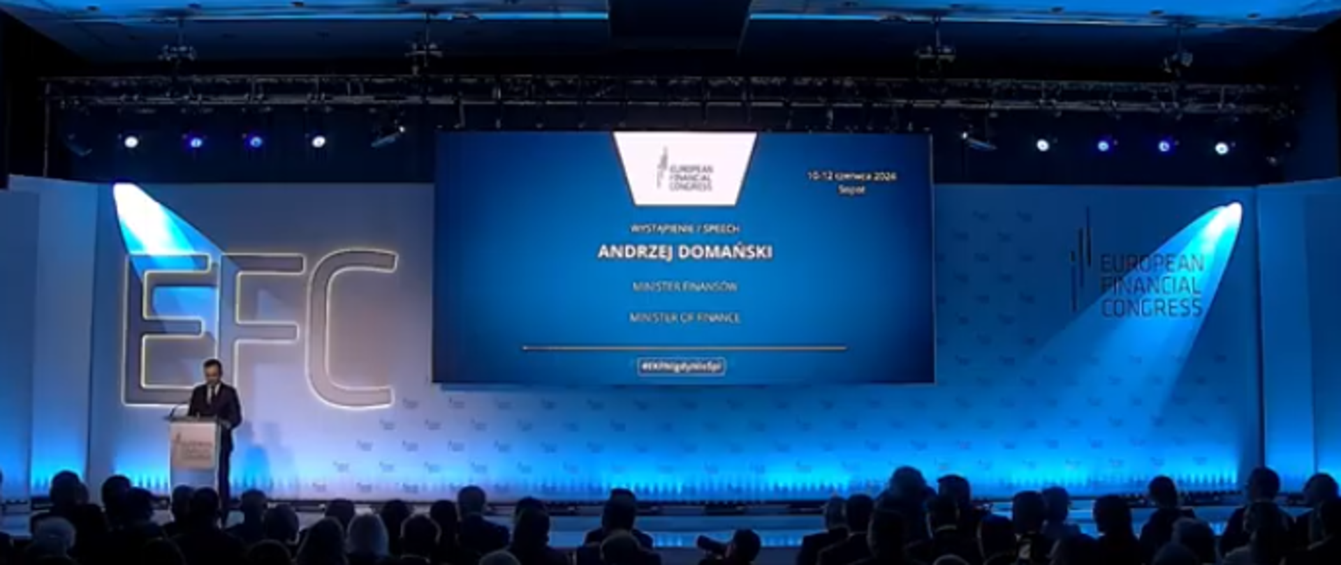 duża sala, kilkadziesiąt osób patrzy na scenę. Na niej przemawia minister finansów. W tle napis Europejski Kongres Finansowy
