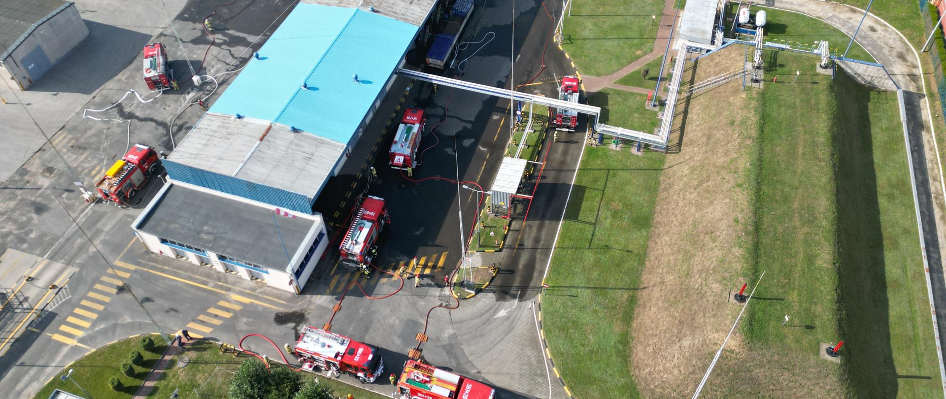 Teren zakładu, widok z góry. Trwają działania gaśnicze.