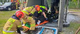 Ćwiczenia z zakresu ratownictwa technicznego. Zdjęcie przedstawia strażaków PSP oraz OSP oraz Policjantów podczas udzielania pierwszej pomocy osobom poszkodowanym podczas ćwiczeń.