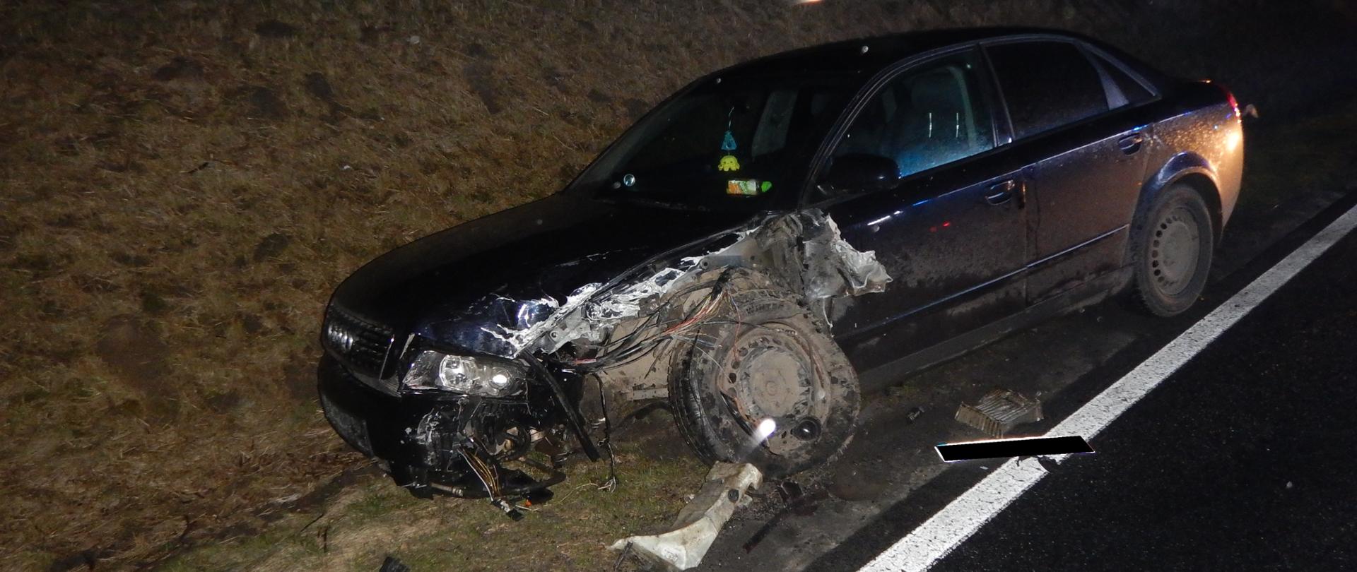 Zdjęcie przedstawia uszkodzony bok i przód samochodu
