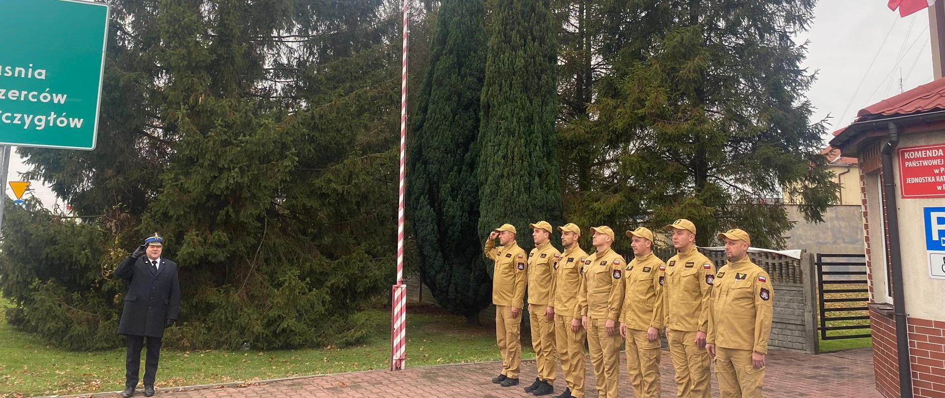 Strażacy KP PSP Pajęczno śpiewają hymn Polski pod masztem