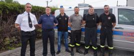 Funkcjonariusze Państwowej Straży Pożarnej i Ochotniczej Straży Pożarnej oraz Policji na tle samochodu Regionalnego Centrum Krwiodawstwa i Krwiolecznictwa na wspólnie pozują do zdjęcia.