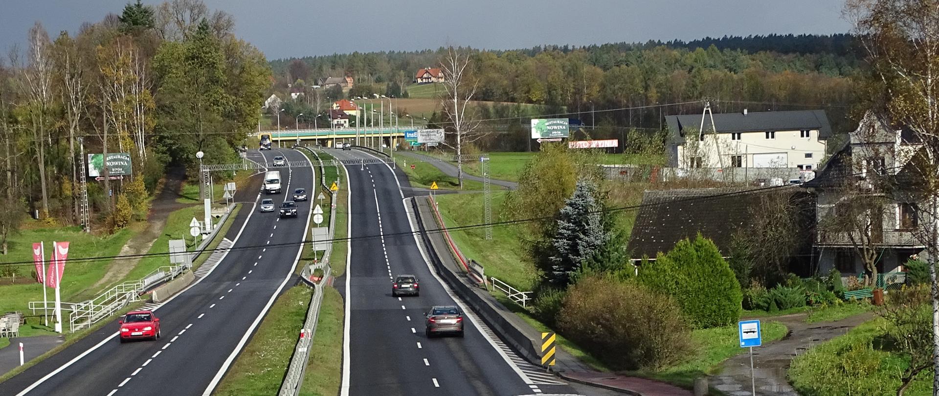droga dwojezdniowa z pojazdami, w oddali wiadukt, teren górzysty