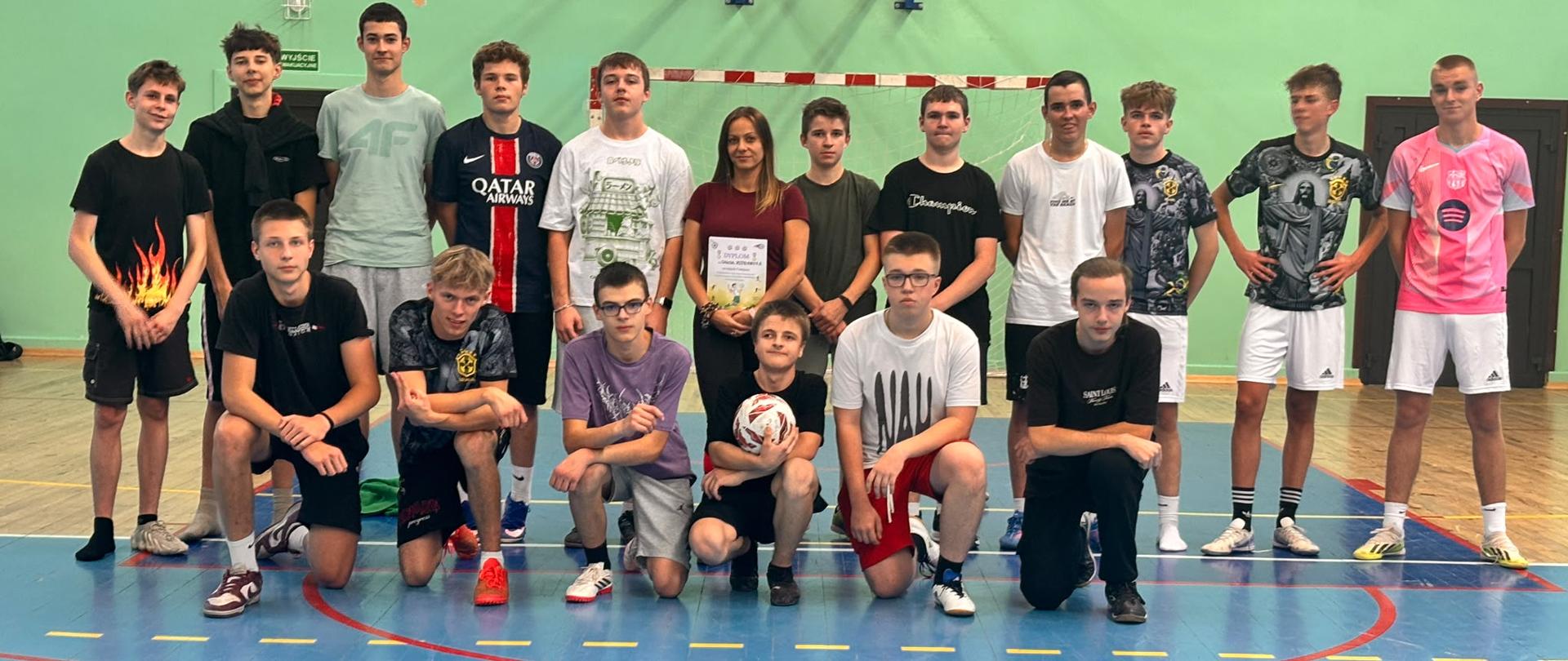 Mieszkańcy internatu biorący udział w meczu na zdjęciu pamiątkowym z Panią Justyną Foryt między nimi 