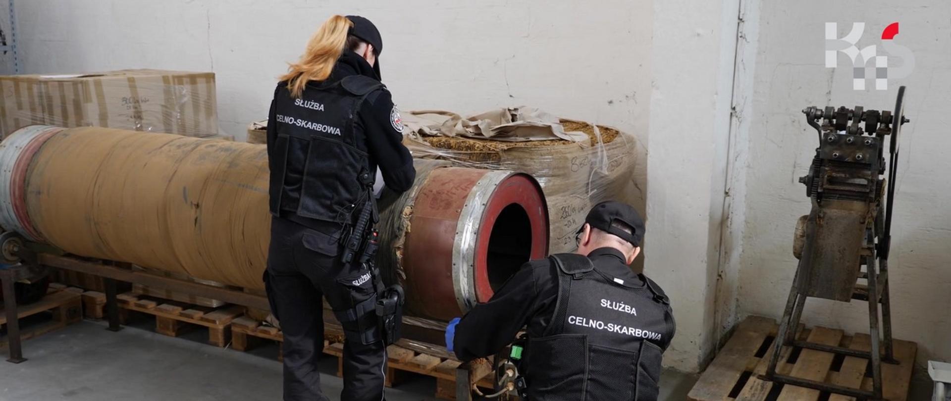 Funkcjonariusze stojący przy maszynie do suszenia i cięcia liści tytoniu