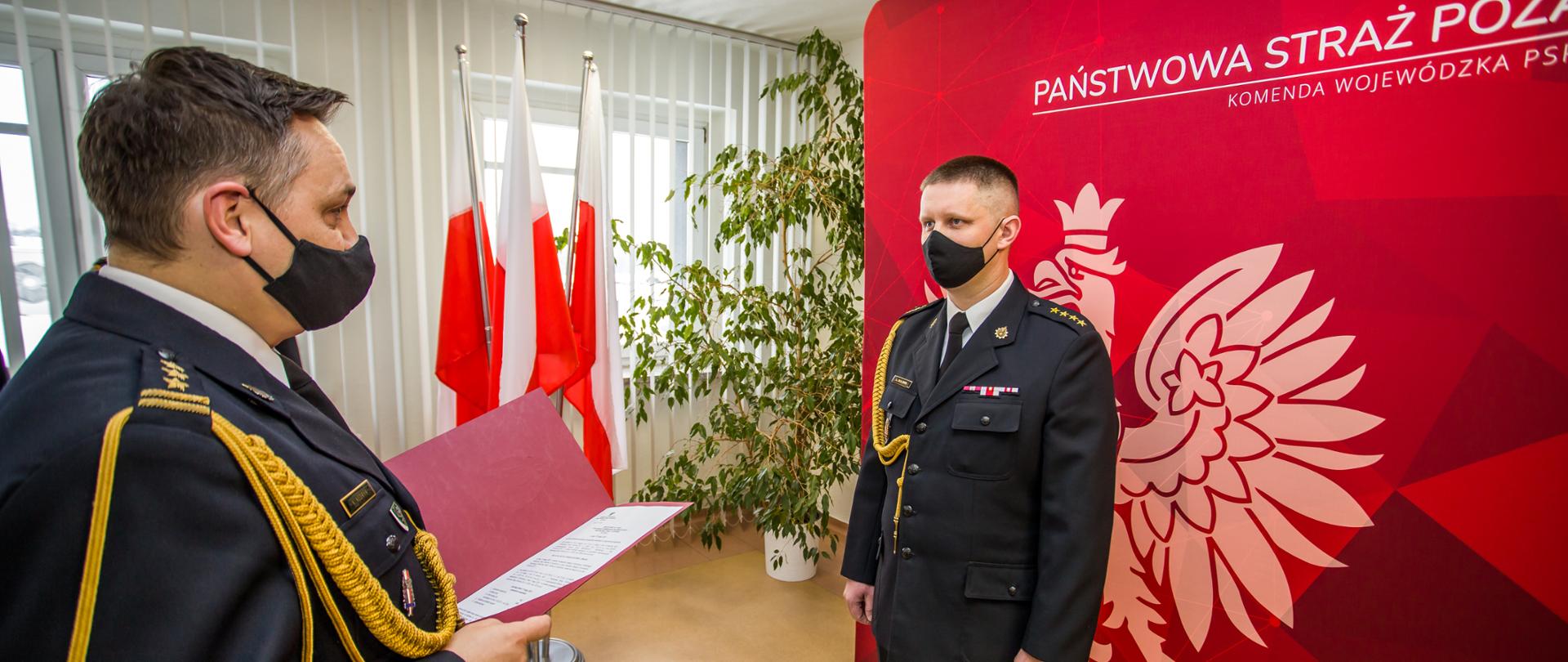 Zdjęcie przedstawia dwóch strażaków PSP w mundurze galowym podczas uroczystości przekazania decyzji o powołaniu na stanowisko Zastępcy Komendanta Powiatowego PSP w Kluczborku.
Po lewej st. bryg. Krzysztof Kędryk Opolski Komendant Wojewódzki PSP w Opolu a po prawej stronie st. kpt. Łukasz Olejnik Zastępca Komendanta Powiatowego PSP w Kluczborku - dotychczas naczelnik wydziału operacyjnego KW PSP w Opolu.